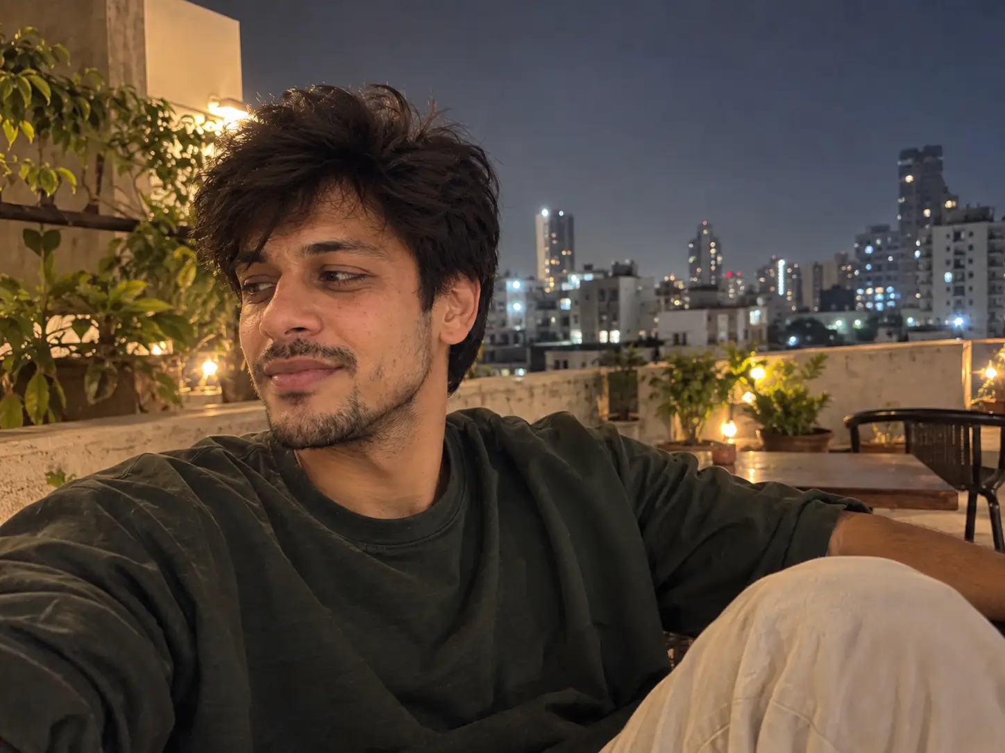 AI-generated example photo of a man on a rooftop terrace at night, made with UnrealShot